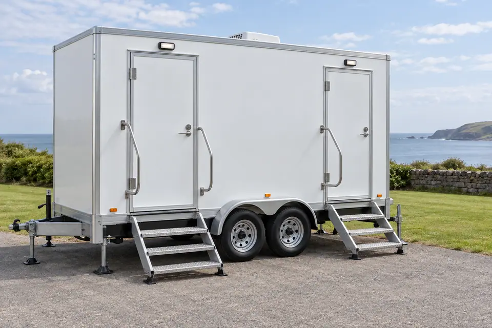 White restroom trailer with separate entrances and handrails